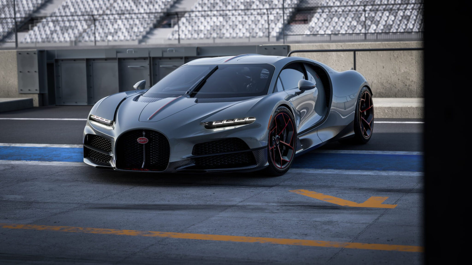 A sleek gray sports car with a streamlined design, bearing the prestigious Équipe Pur Sang emblem, is parked on a race track. The Bugatti flaunts black and red accents, situated near empty spectator stands.