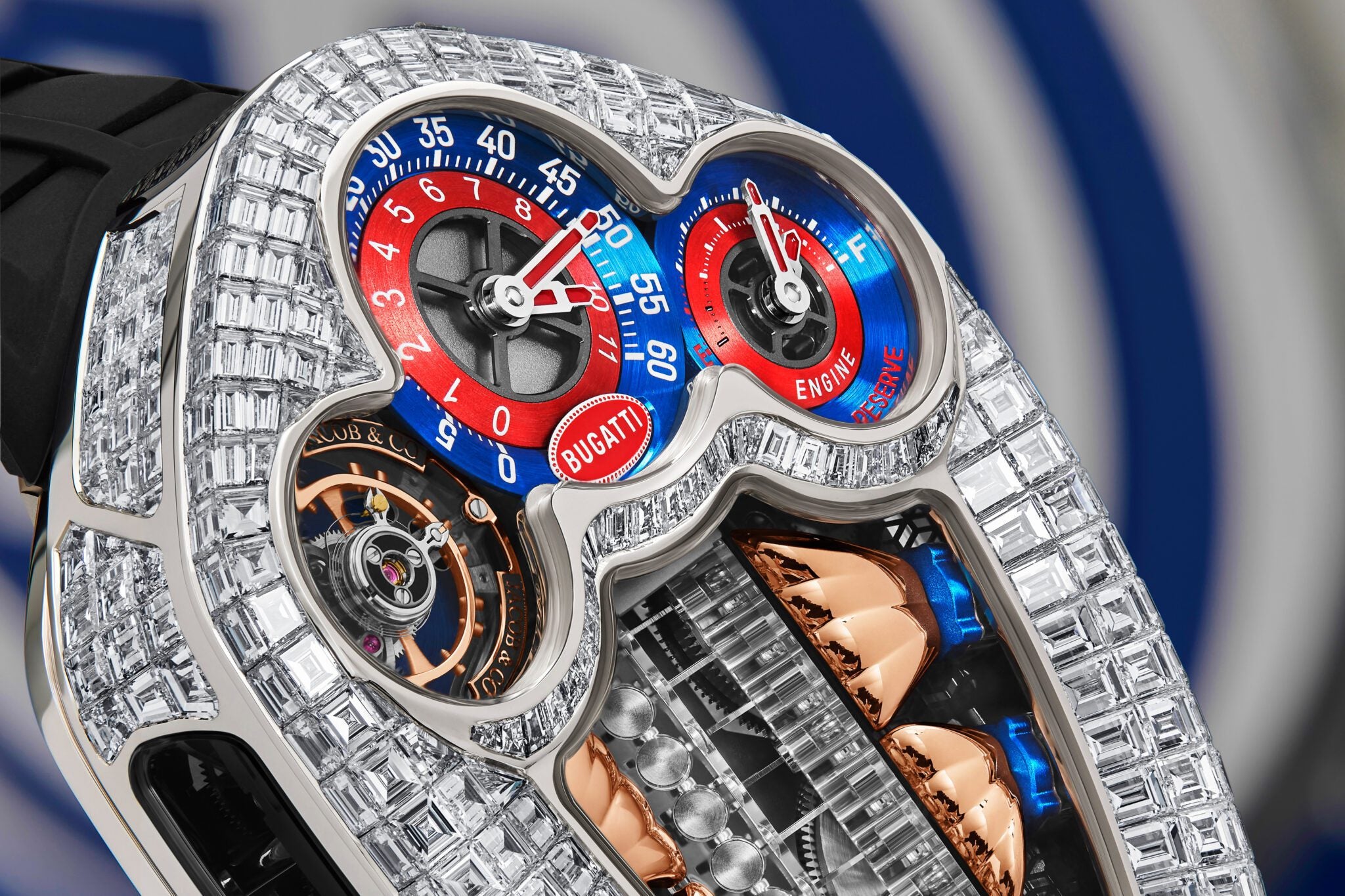 Close-up of a luxury watch with a diamond-encrusted case, two colored dials marked “Bugatti,” and visible intricate mechanical components—an exquisite example of haute horology from Jacob & Co. x Bugatti.