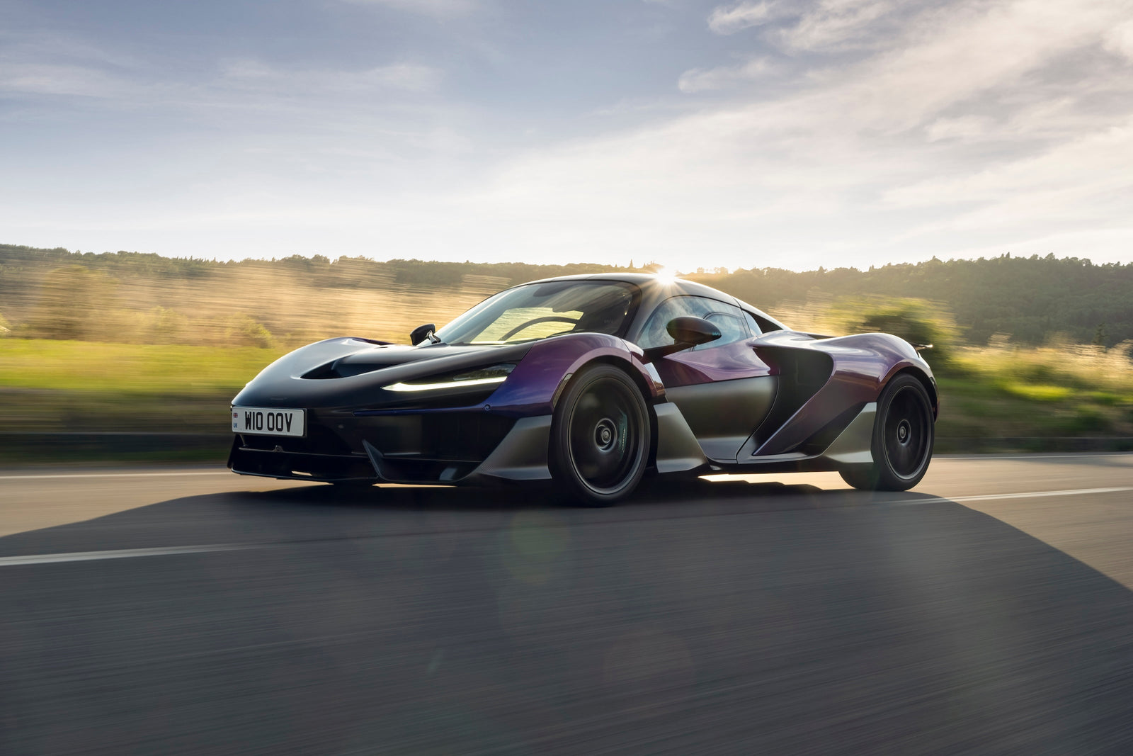 A McLaren W1 hypercar parked on the lush green grass at The Quail during Monterey Car Week.