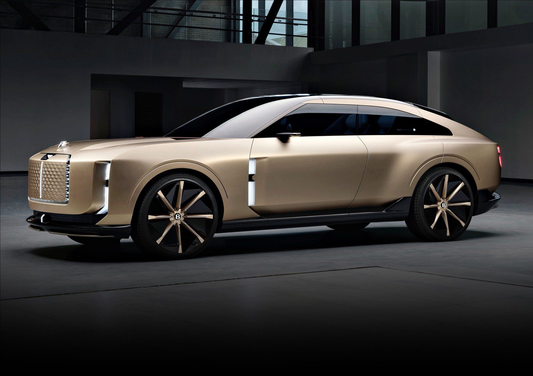 A matte gold Bentley concept luxury SUV with large wheels, sharp lines, and a sleek, modern design is parked indoors under soft lighting—a glimpse into the future of elegant electric vehicles.