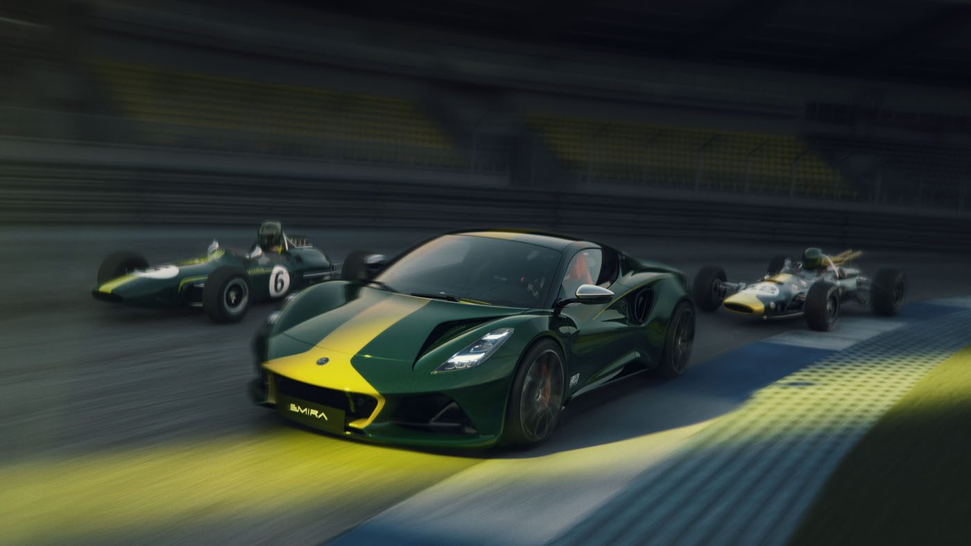A modern green and yellow Lotus Emira Jim Clark Edition sports car races on a track alongside two vintage race cars, all moving at high speed with blurred backgrounds.