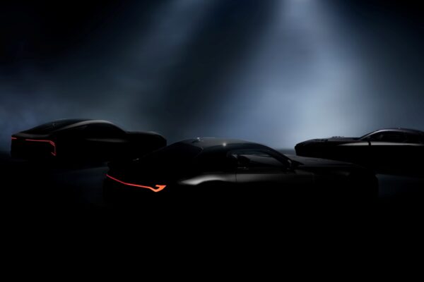 Three sleek, dark Lexus sports cars are partially illuminated under spotlights, with red accent lights on their rear sections visible through the darkness—hinting at a reveal on December 5th.