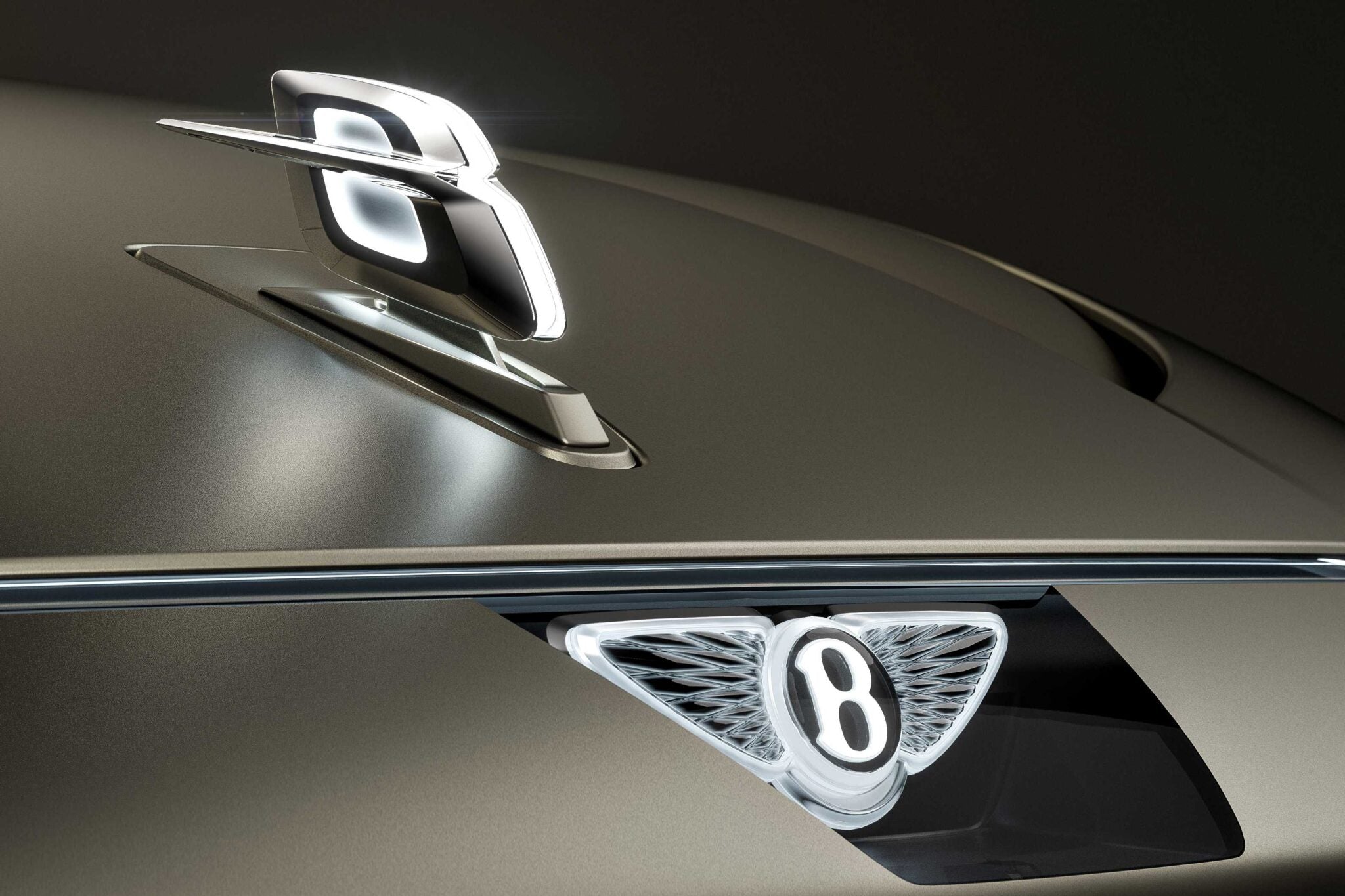 Close-up of a Bentley car hood, featuring the illuminated emblem and hood ornament—hinting at Bentley to reveal more about its upcoming EV and a limited-run model coming before year-end.