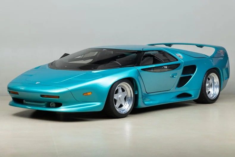 For sale: A 1993 teal sports car that exudes elegance with its sleek design, large rear spoiler, and prominent air intakes. This Vector Avtech WX-3 model is a rare find for enthusiasts seeking both style and performance.