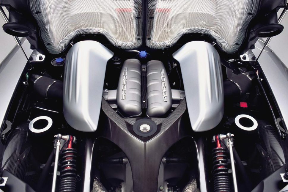 Close-up view of a Porsche engine bay, featuring two large silver air intake covers and visible suspension components—an impressive sight among the 10 Production Cars That Pack a V10 Engine.