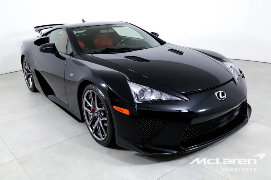 Black Lexus sports car with a red interior in a showroom, angled to the left. Branding shows McLaren Charlotte.