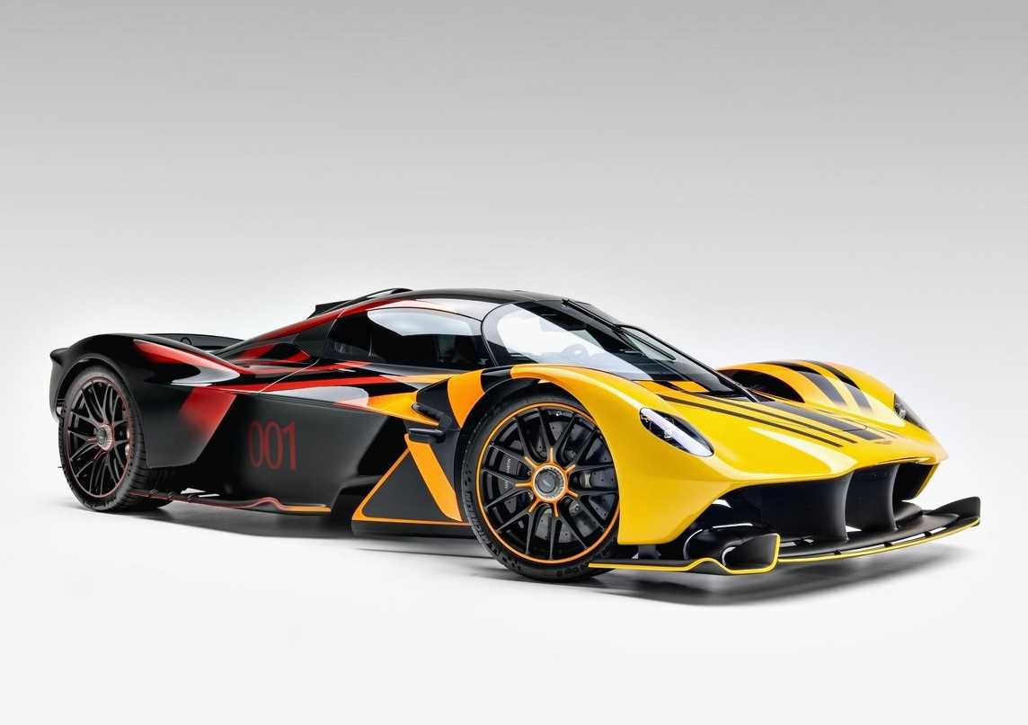 A yellow and black Aston Martin Valkyrie with red accents and the number 001 on its side, photographed on a plain white background, is now for sale at O’Gara Coach.