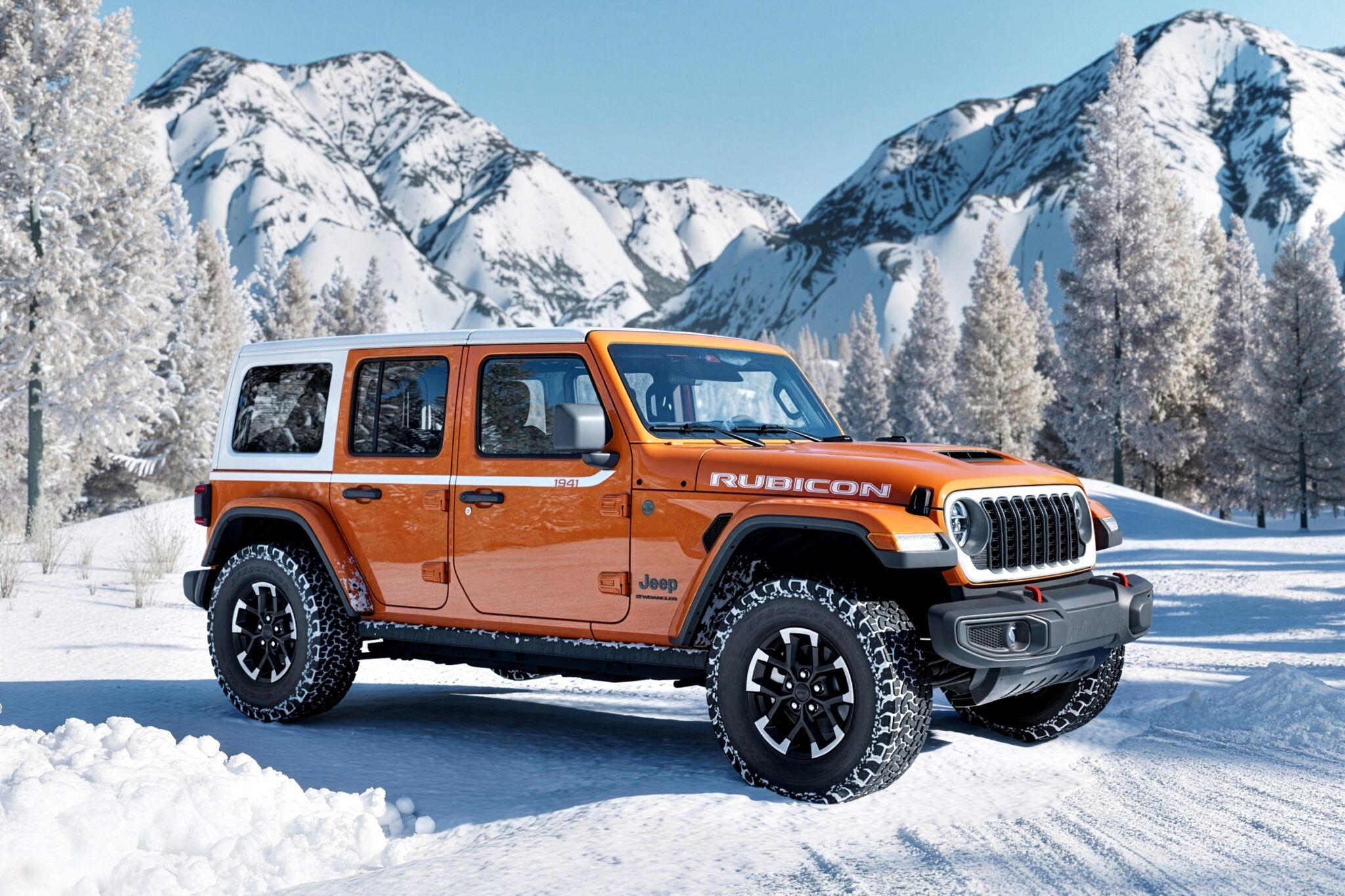 An orange Limited Edition Jeep Wrangler Rubicon is parked on a snowy road, set against snow-covered mountains and trees, celebrating the brand’s 85th Anniversary.