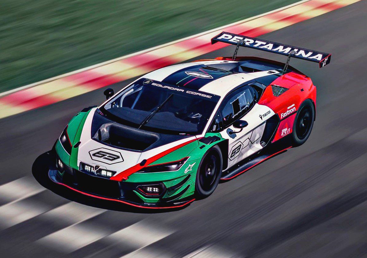 A Lamborghini race car with a green, white, and red livery speeds on a race track. The car features sponsor logos and a large rear wing.
