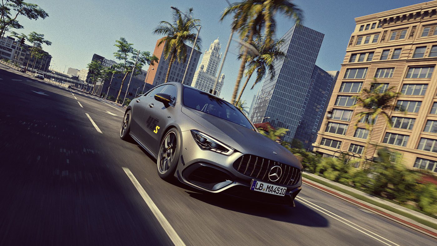 A matte grey Mercedes-Benz sports car drives down a palm-lined city street with modern buildings in the background under a clear sky.