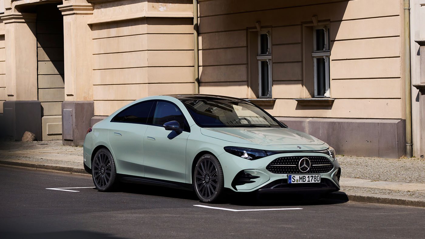 A light green Hybrid CLA 220 Mercedes-Benz sedan parked on a city street beside a beige building in daylight.