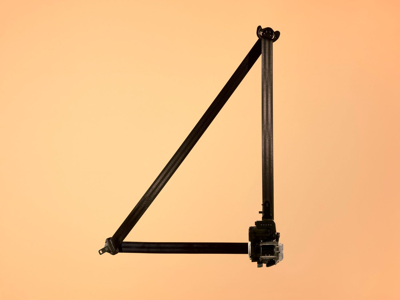 A black triangular metal frame with joints at each corner is displayed upright against a plain peach-colored background.