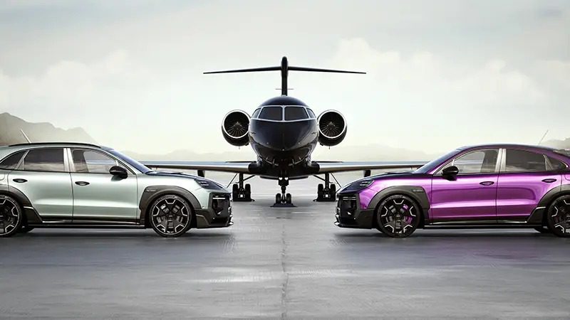 Two luxury cars, a silver TECHART MAGNUM and a purple Porsche Cayenne, are parked facing a private jet on an open tarmac with mountainous scenery in the background.