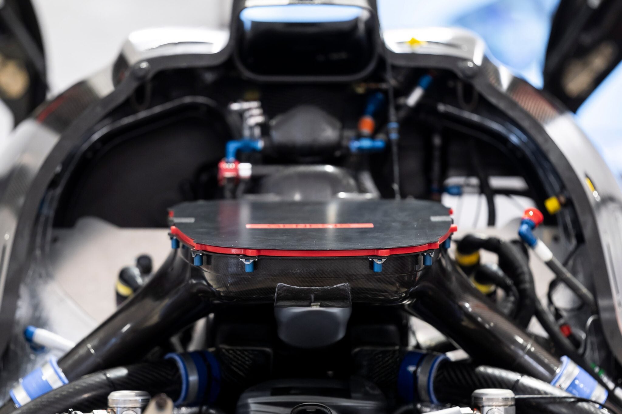 Close-up view of the GMR‑001 Hypercar’s V8 Twin-Turbo engine, showcasing carbon fiber components, wiring, and hoses—embodying Genesis Magma Racing performance.