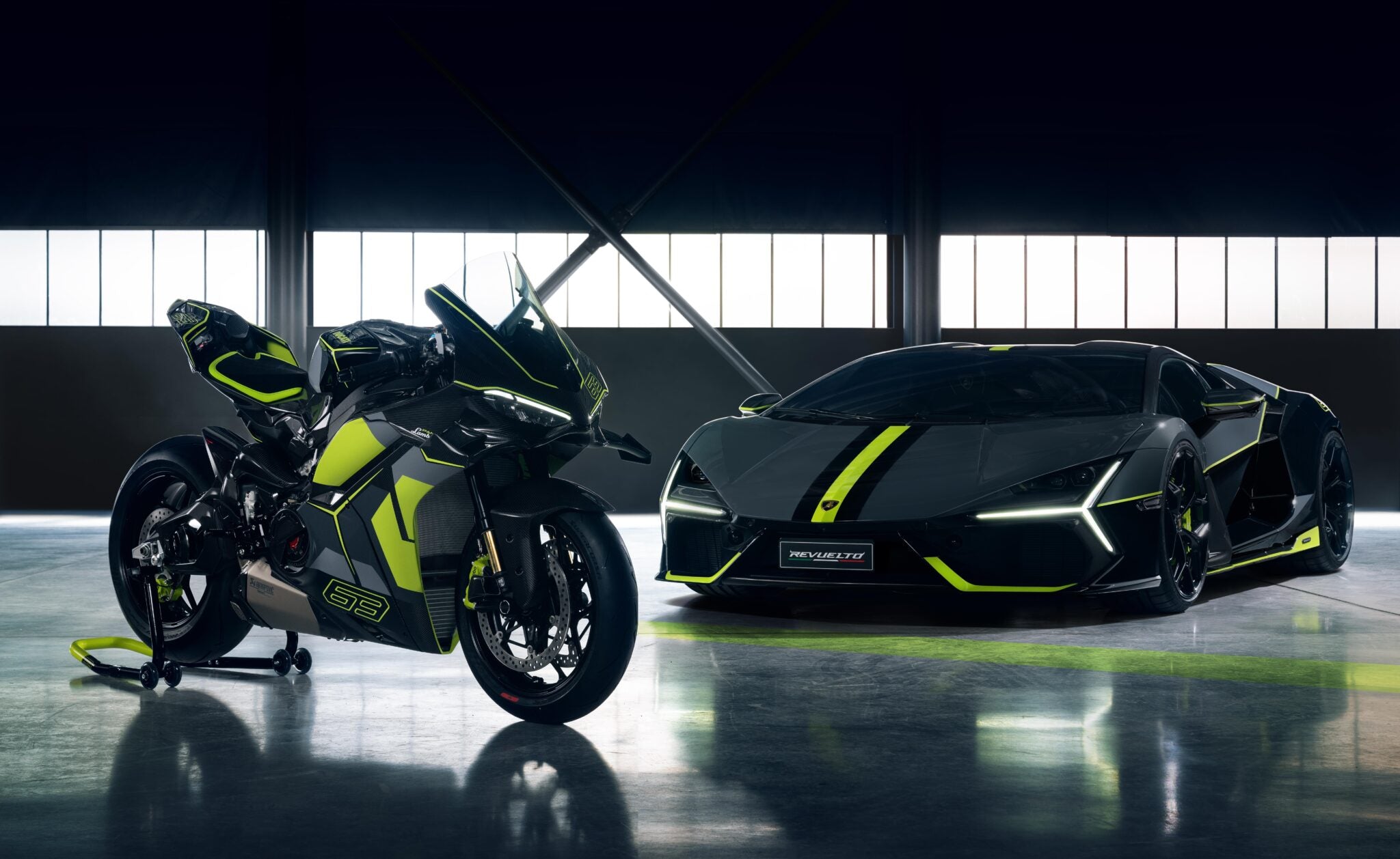 A sleek, limited-edition sports motorcycle and a luxury car in black with neon green accents are displayed indoors under soft lighting, against a backdrop of large windows.