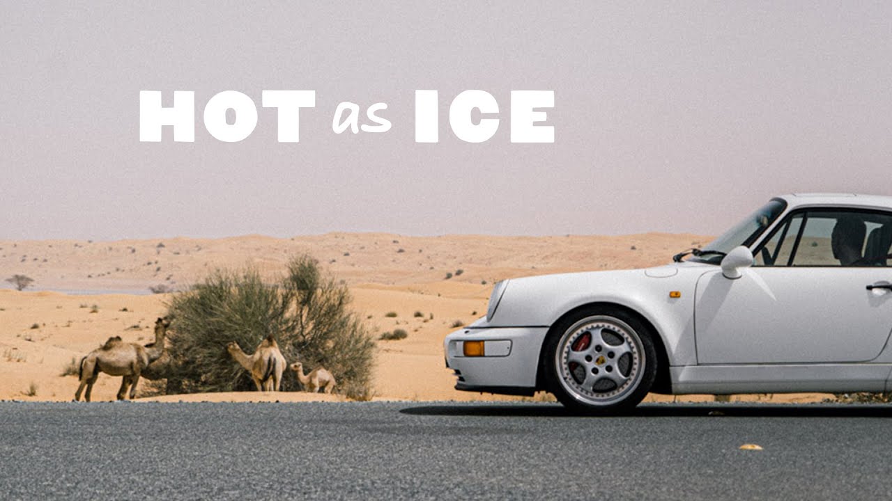 A white sports car is parked on a road beside a desert with camels; the text "HOT as ICE" appears at the top.