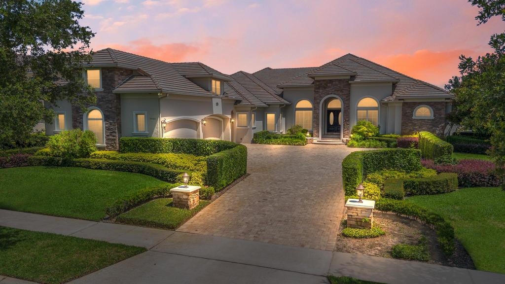 A luxury custom estate in Keene's Pointe, Windermere Florida, featuring a spacious house with a grand driveway.