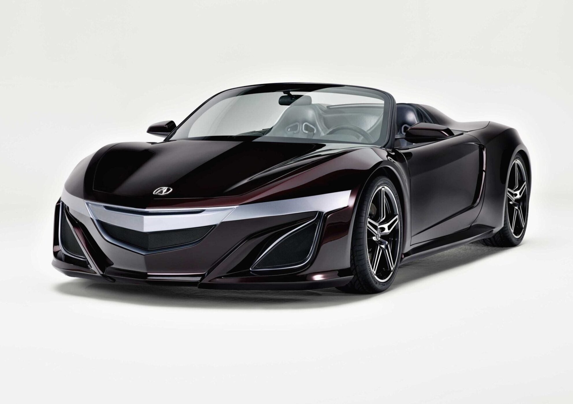 A sleek, dark purple convertible sports car with a low profile and modern design is showcased against a plain white background—perfect for the spotlight at Monterey Car Week or a high-profile 2026 Auction.