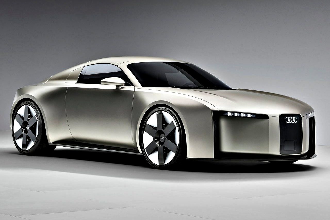 A silver Audi concept car from 2025 with a sleek, futuristic design, angular lines, narrow headlights, and large black-and-silver wheels is showcased in a studio setting.