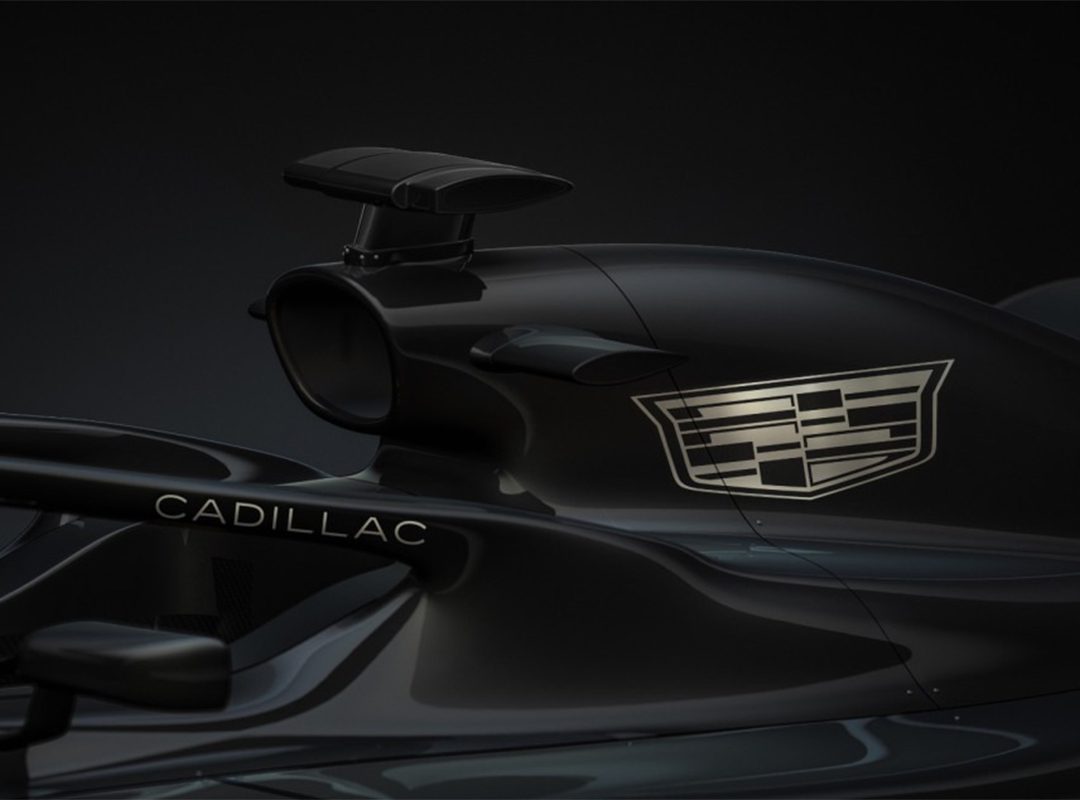 Close-up of a black F1 car’s air intake and side mirrors, featuring the Cadillac logo and brand name—highlighting American-Built Power Units against a dark background.