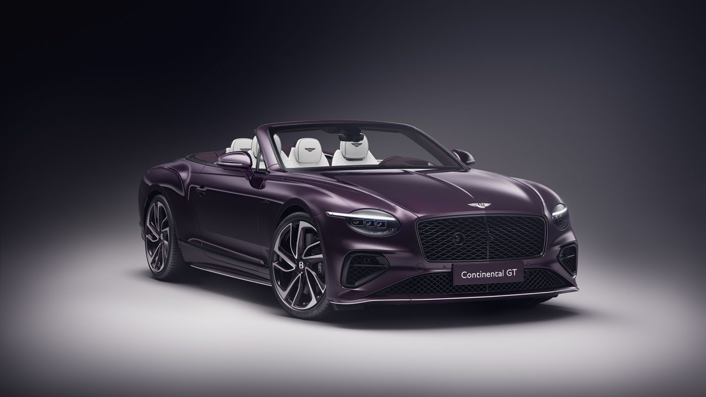 A sleek, purple Bespoke Bentley convertible sports car with the top down showcases a luxurious interior against a dark background, reminiscent of the elegance found in a $1.7M auction masterpiece.
