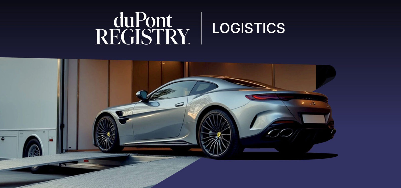 A silver luxury sports car is being loaded onto an enclosed vehicle transporter with a duPont REGISTRY Logistics banner above, exemplifying premium Luxury Vehicle Transport.