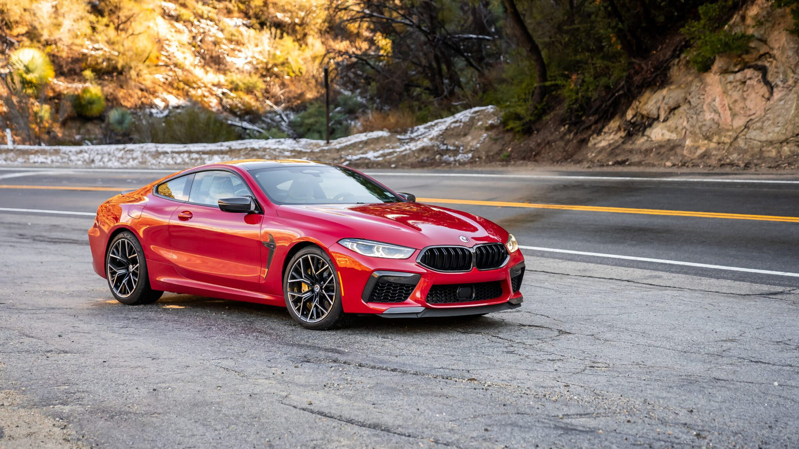 An image of an Imola Red BMW M8 Competition parked outdoors.