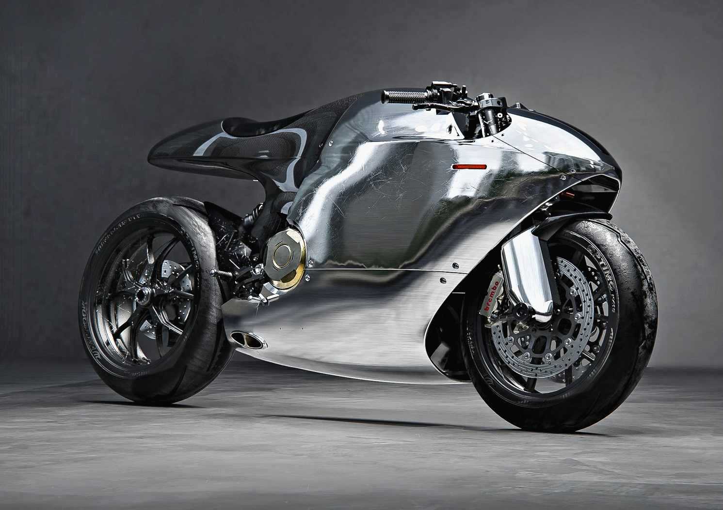 A sleek, modern motorcycle with a reflective, polished metal body and minimalist design sits on a gray studio floor, resembling a piece of futuristic sculpture.