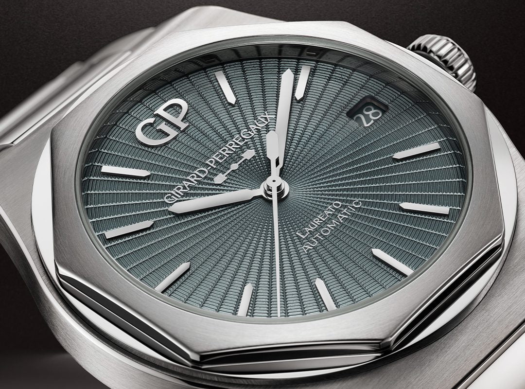 Close-up of a Girard-Perregaux Laureato 50th Anniversary watch featuring a textured blue dial, silver hands and indices, date display at 3 o'clock, and a sleek stainless steel case.