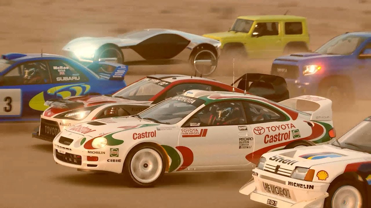 Multiple rally cars, including a Toyota Castrol, race closely on a dirt track with dust in the air, capturing the excitement of Gran Turismo 7. Other cars and a yellow SUV are visible in the background.