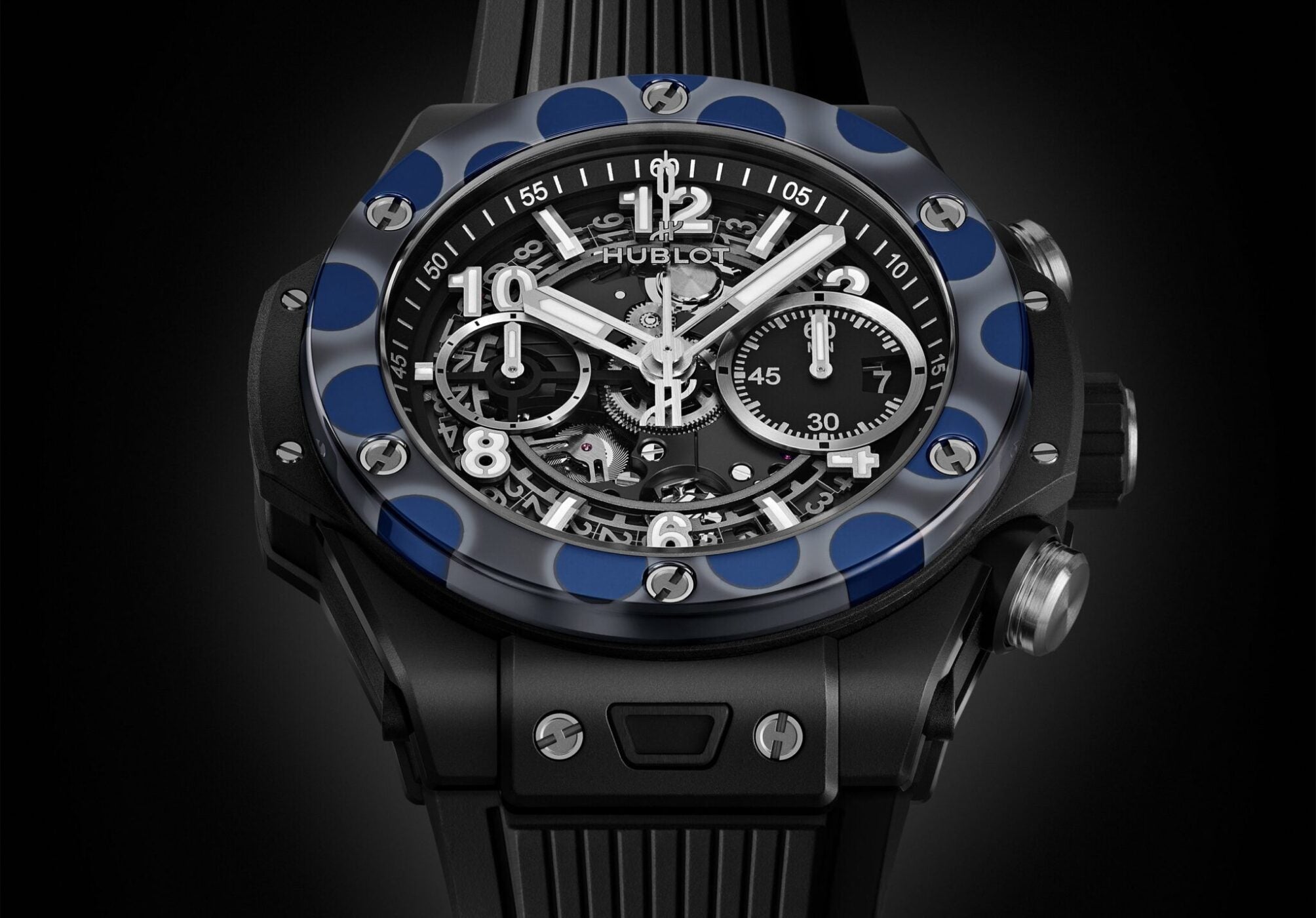 This Hublot Big Bang watch showcases a striking black and blue visible mechanical design with multiple dials, and is completed with a sleek black rubber strap.