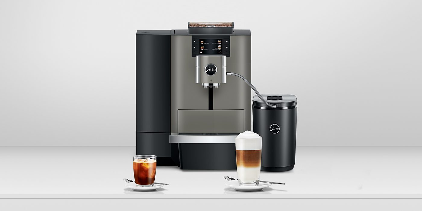 A modern espresso machine with a milk frother, perfect for any office barista, accompanied by a glass of iced coffee and a glass of layered latte on saucers.