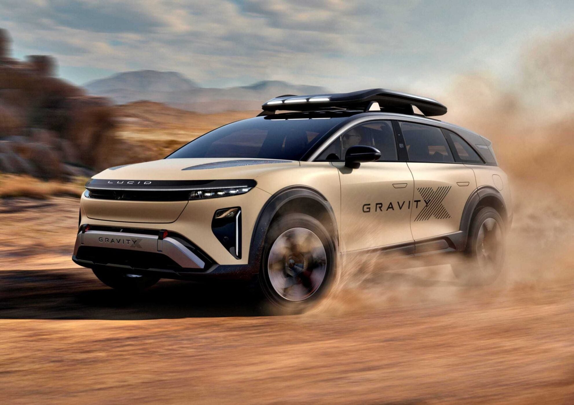 A beige Lucid Gravity SUV with a roof box drives off-road, kicking up dust in a desert landscape—echoing the trail-ready spirit of the Pebble Beach Debut: Rugged Lucid Gravity X Concept with 828 HP and adventure-focused upgrades.