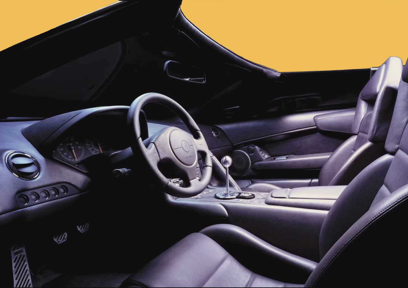 Interior view of an open-top Lambo sports car with black leather seats, a manual gear shift, and a steering wheel, with a yellow background visible through the windows.