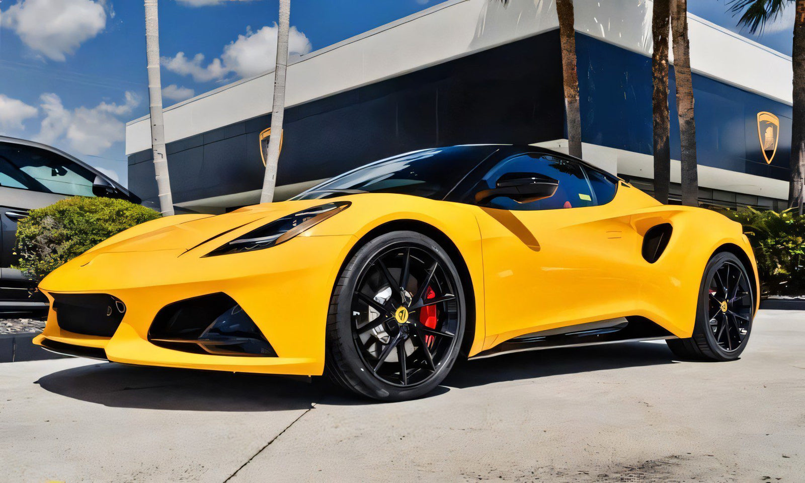 A yellow sports car with black wheels, for sale as the best sports car under $100k, is parked outside a modern building with palm trees in the background.
