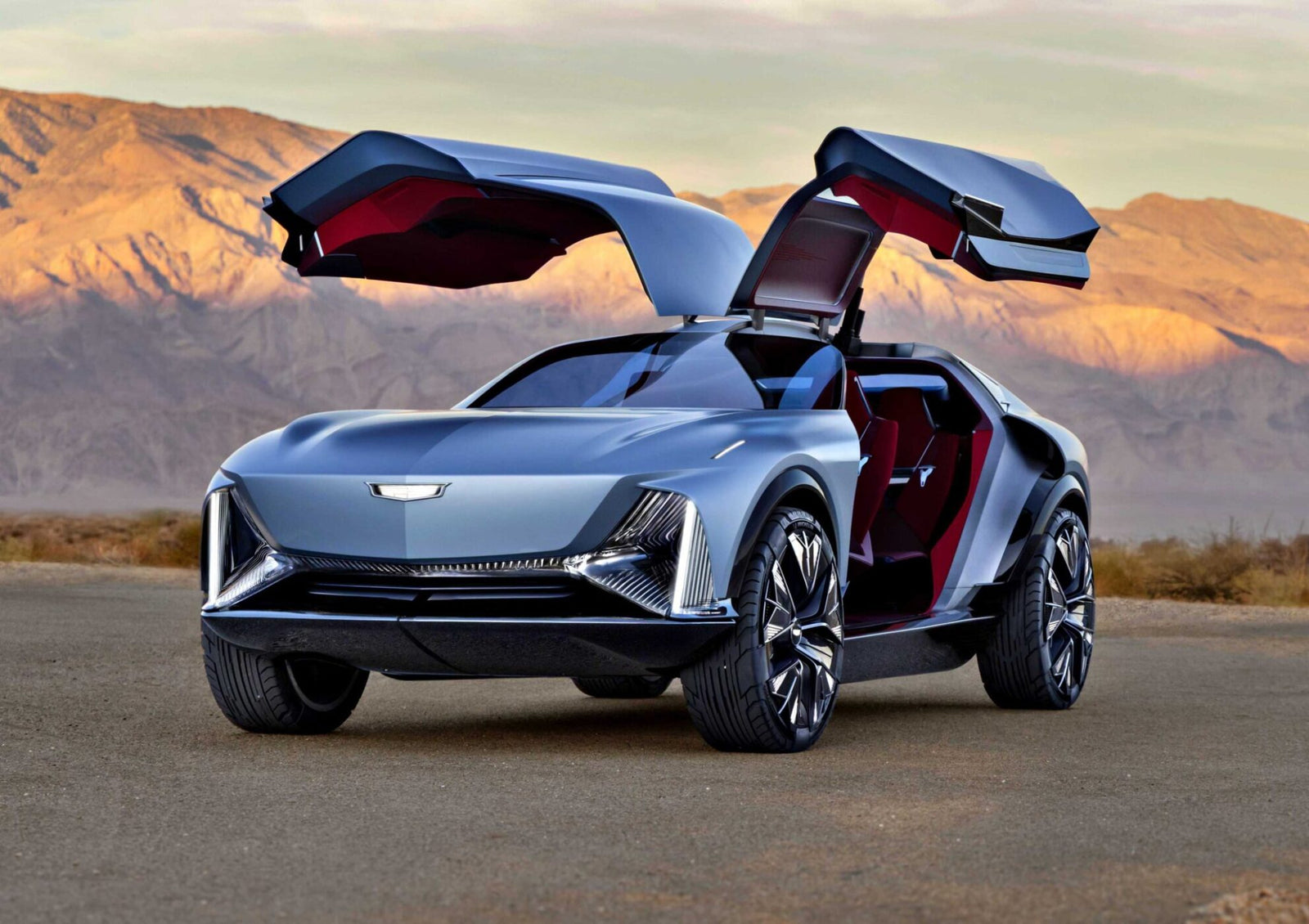 A silver concept car with gullwing doors open is parked on a road with mountains in the background, showcasing Extreme Vision in the world of future luxury EVs.