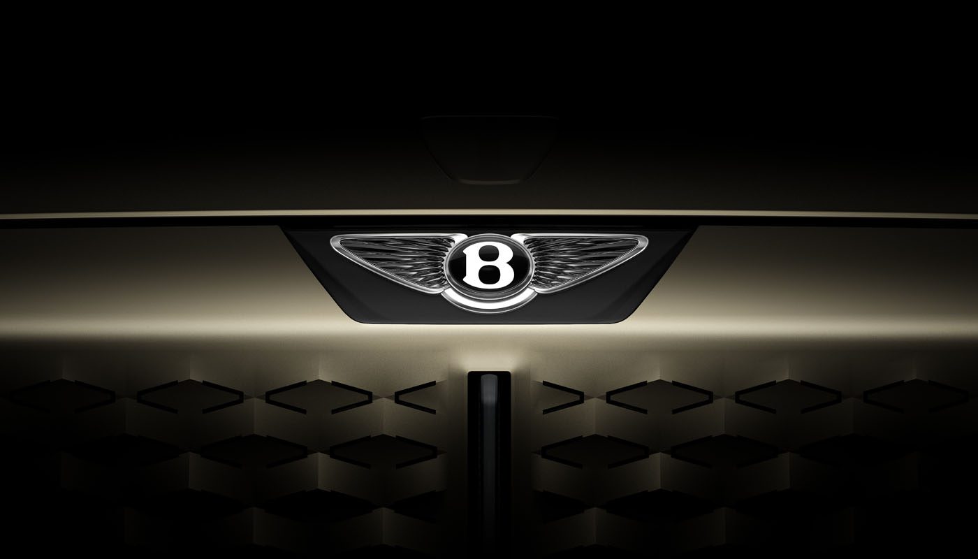 Close-up of the front grille of a car featuring the illuminated Bentley logo with a dark, shadowed background.