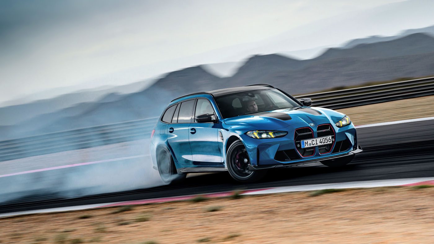 The new BMW M3 gracefully drifts on the racetrack, leaving a mesmerizing smoke trail with majestic mountains in the background.
