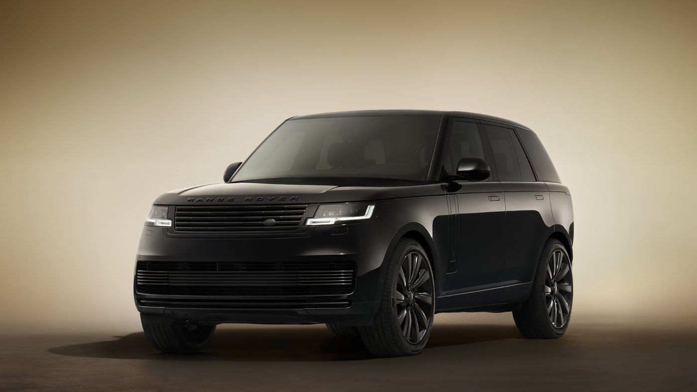 A SV Black Range Rover SUV is parked indoors on a neutral, softly-lit background, viewed from the front left corner.