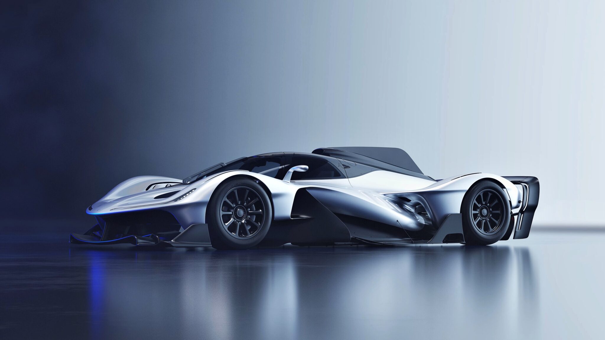 The production version of the Red Bull RB17 hypercar is revealed: a futuristic, silver machine with aerodynamic curves and black accents, parked on a reflective surface against a gradient background.