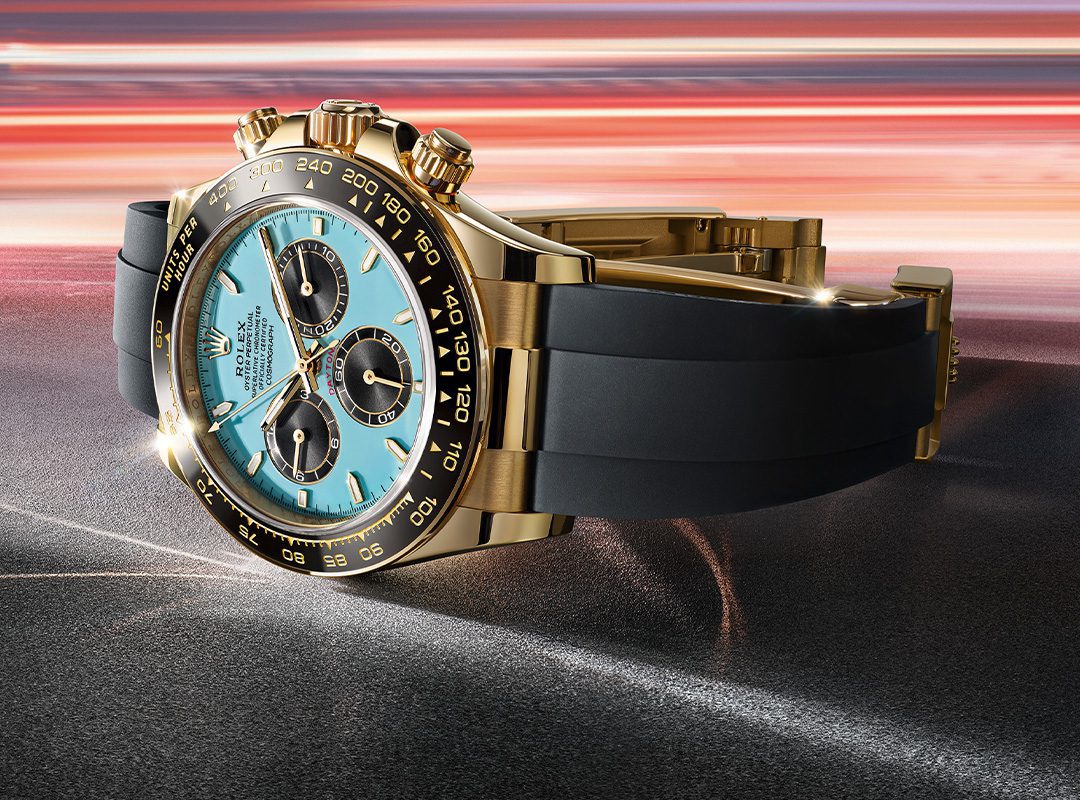 A gold and black Rolex wristwatch with a blue face and gold markings is displayed against a dynamic, blurred background, capturing the essence of 2025 Watches.