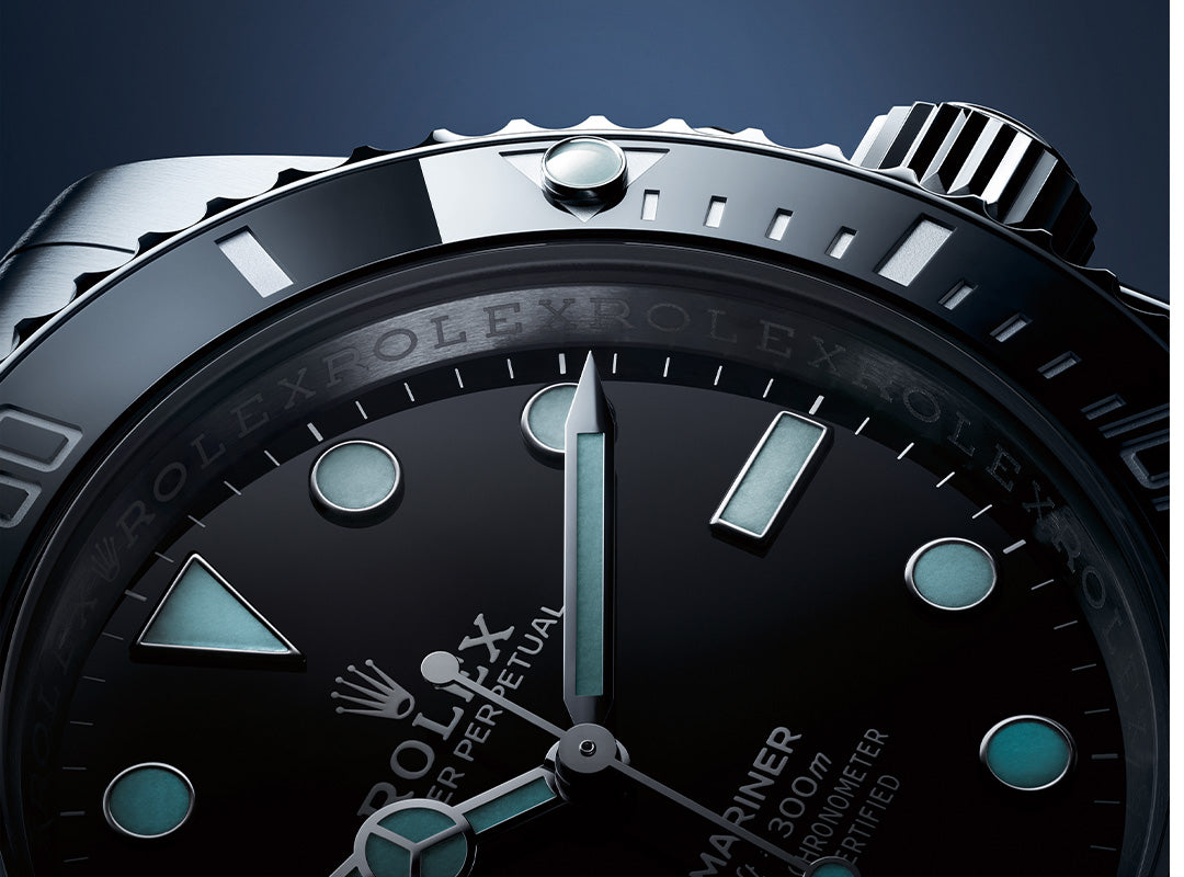 Close-up of a Rolex Submariner watch face, a true collector classic, with luminescent hour markers, rotating bezel, and minute and hour hands set against a dark blue background.