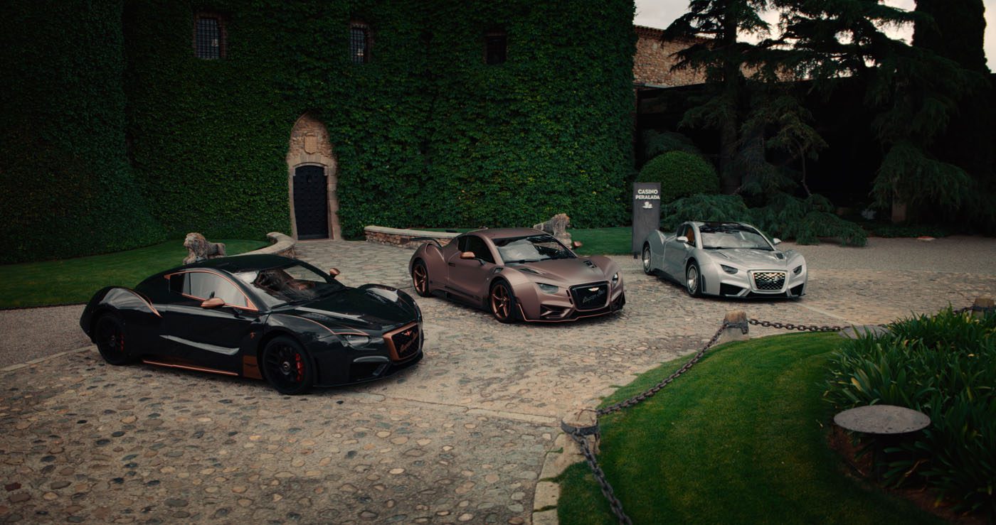 Three luxury sports cars, including a striking Hispano Suiza in hypercar configuration, are parked on a cobblestone driveway before a grand ivy-covered building with a garden.