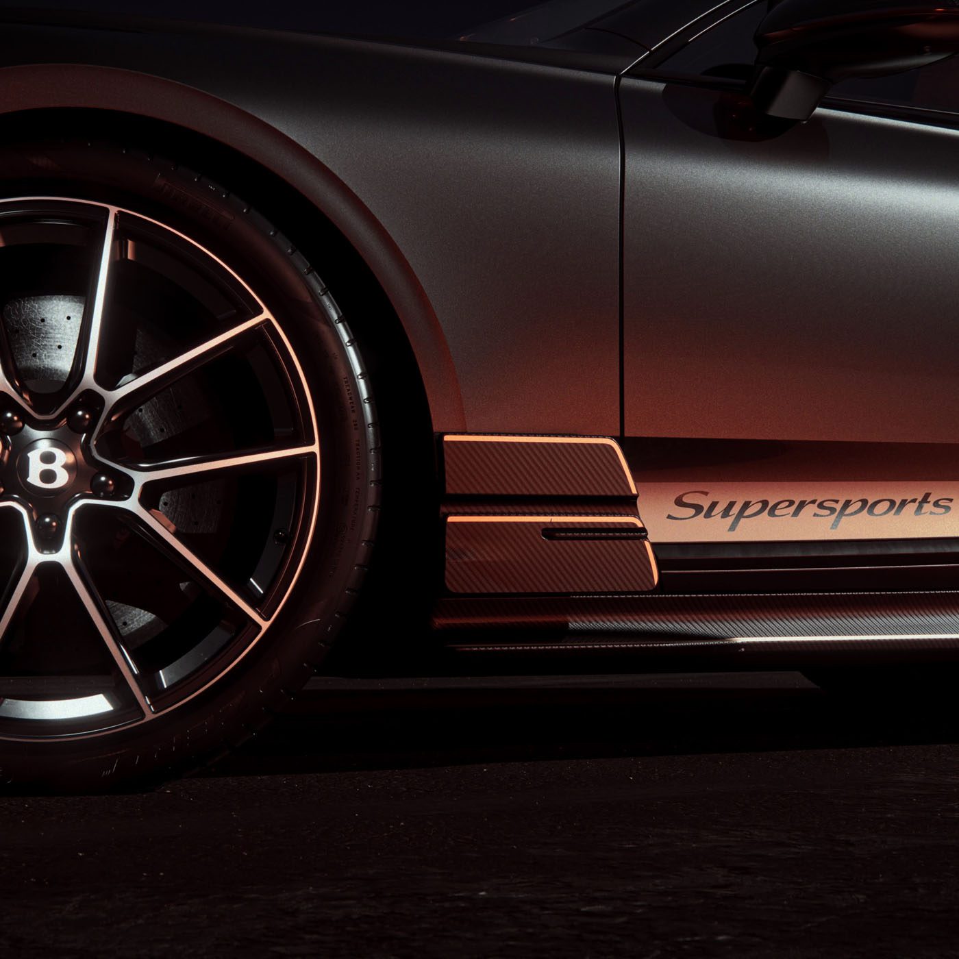Close-up of a black luxury sports car’s front wheel and side panel with the word "Supersports" and bronze accents visible in low lighting.