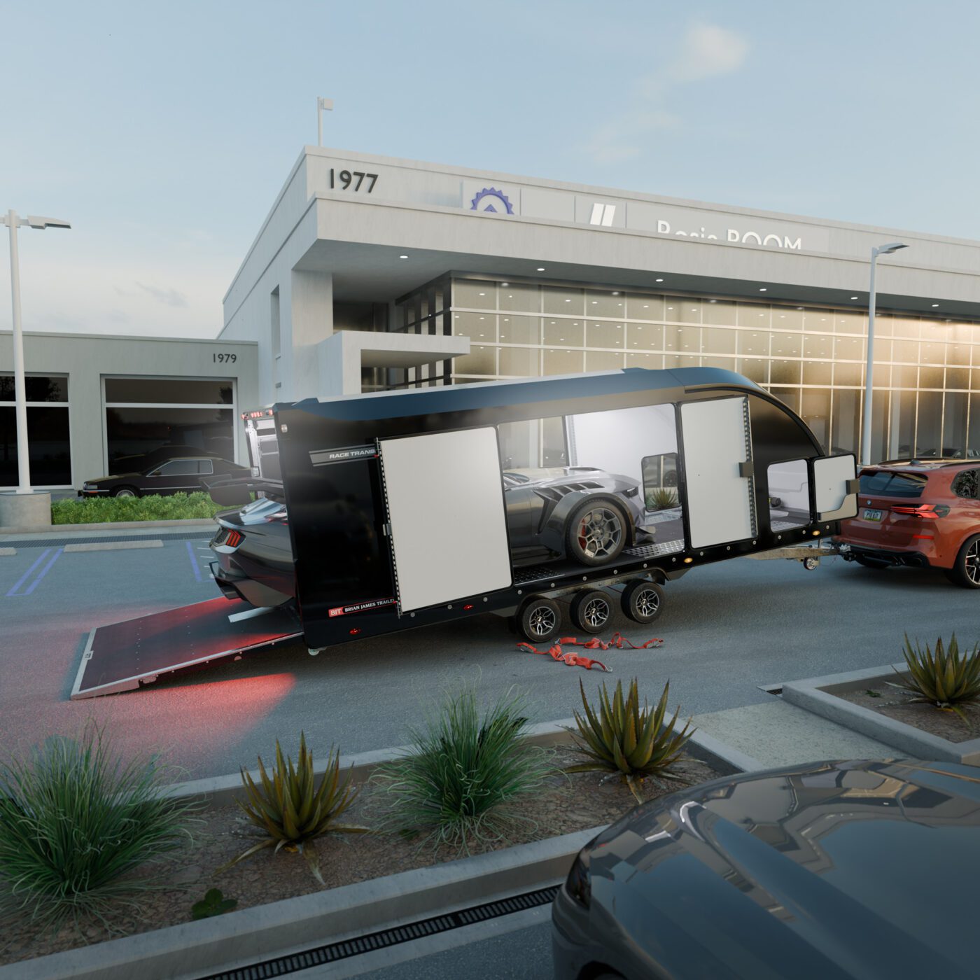 A black Brian James Trailers race transporter with open side and rear doors is parked outside a modern dealership, revealing a car inside. Tools and equipment are scattered nearby.