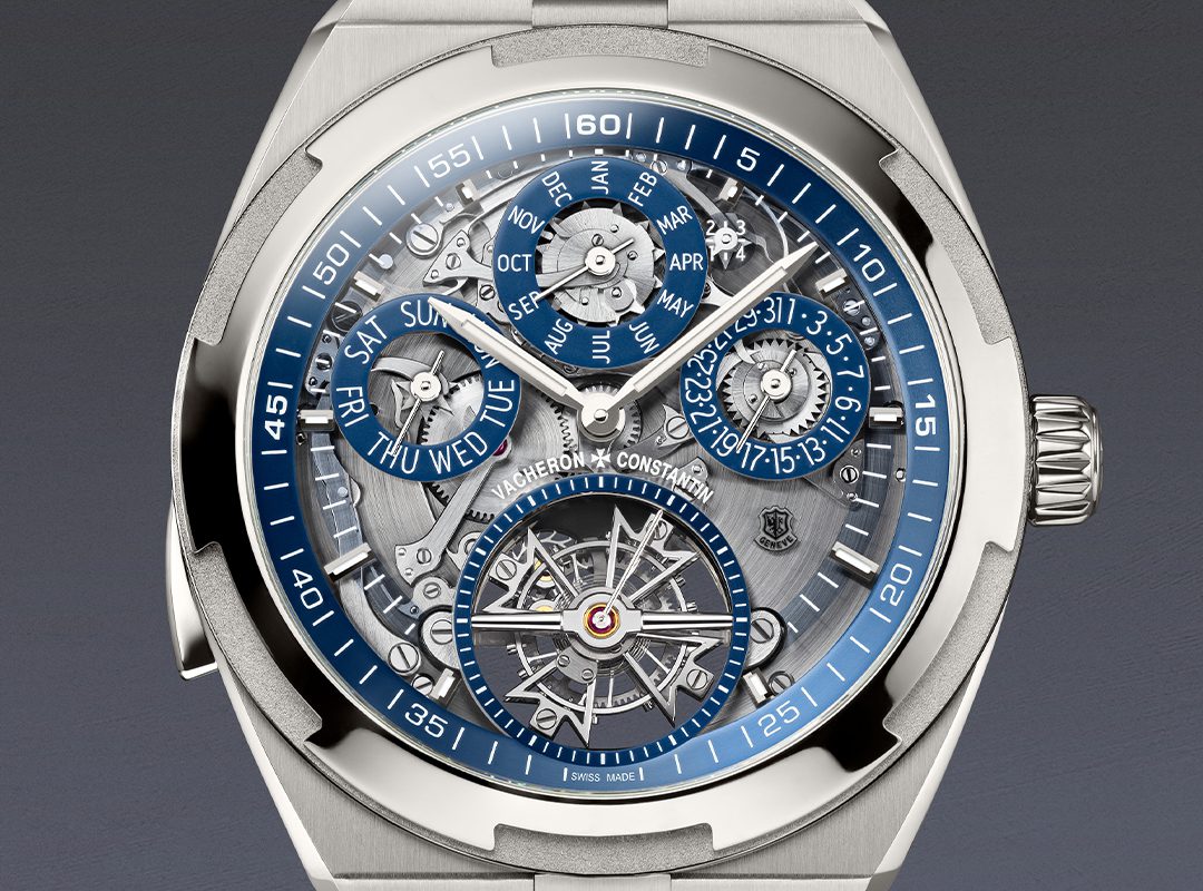 Close-up of a luxury Vacheron Constantin Overseas Grand Complication wristwatch featuring an openface intricate dial with multiple subdials for day, date, month, leap year, and a visible tourbillon mechanism.