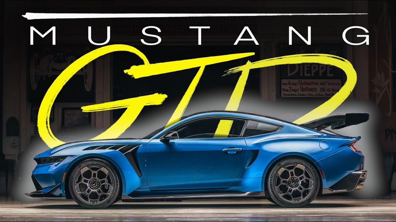 A blue Ford Mustang GTD parked indoors, viewed from the side, with bold text "MUSTANG GTD" displayed above the car—just like one Jay Leno might showcase in his legendary garage.