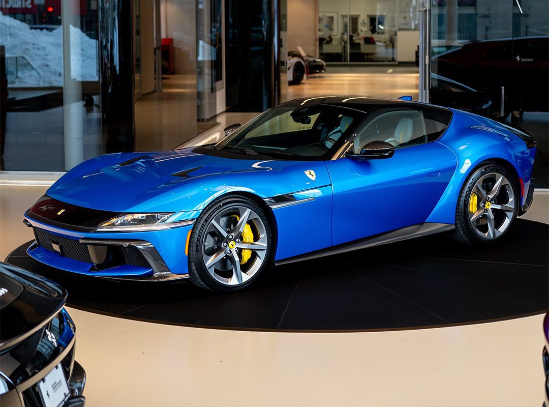A stunning blue sports car with yellow brake calipers, reminiscent of an 830HP Ferrari, is showcased in a showroom.