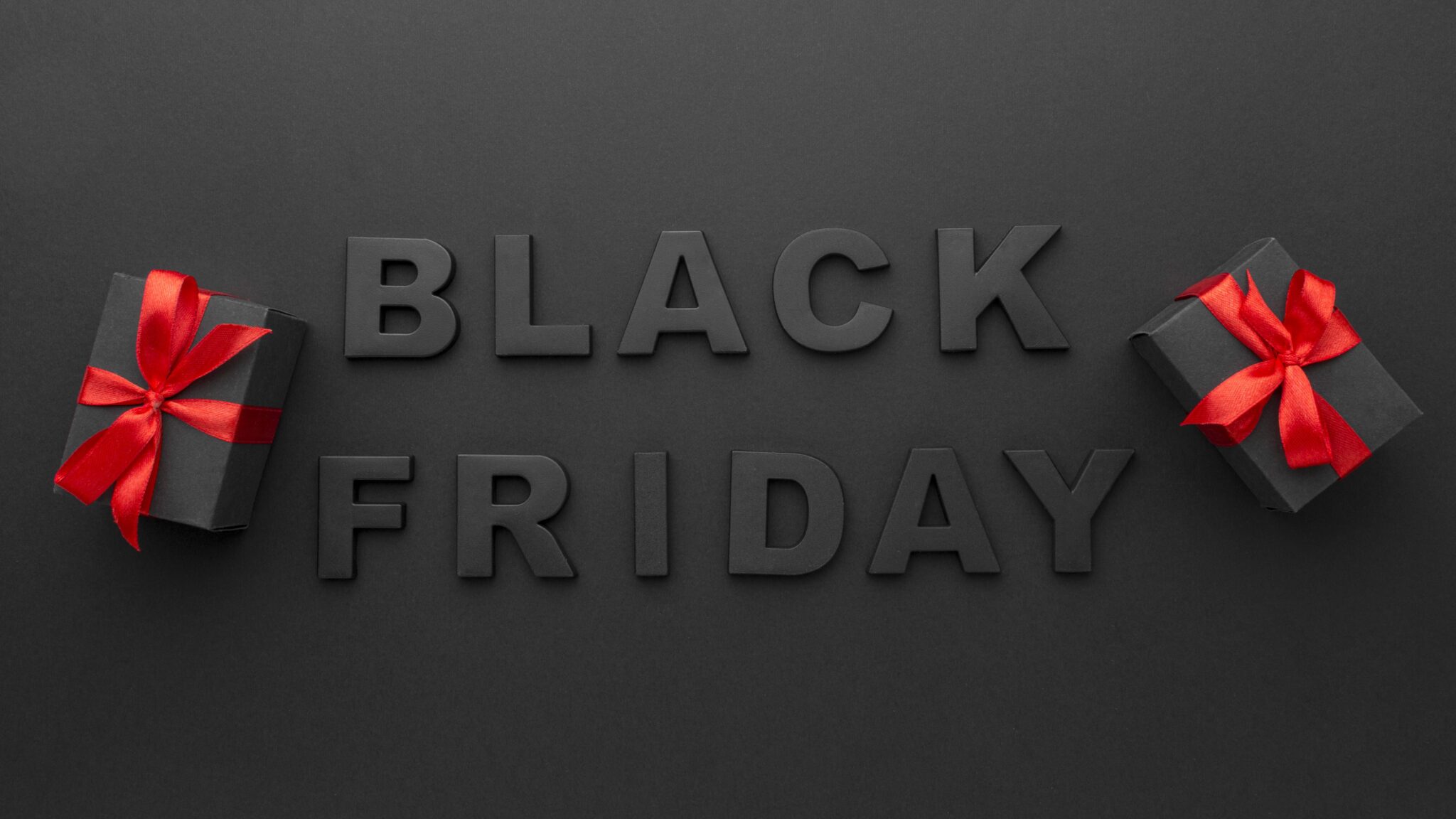 Black Friday 2024 text on a dark background with two black gift boxes wrapped in red ribbons, promising the biggest savings of the year as highlighted by duPont REGISTRY.