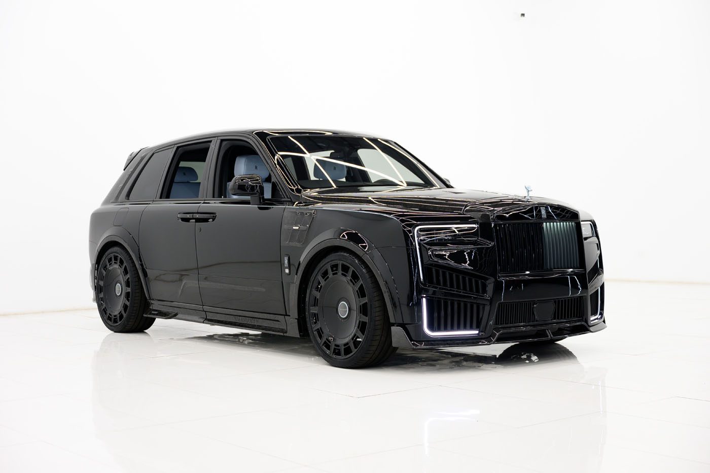 A black 2025 Cullinan luxury SUV with tinted windows and custom wheels, showcased in a minimal white studio setting. Available as a Limited Spec at your Mansory Dealer.